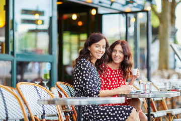 Wall Mural - Beautiful twin sisters drinking coffee