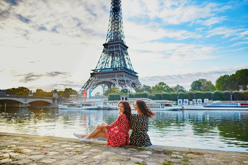 beautiful twin sisters near the eiffel tower in paris, france