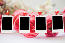 4 Blank Instant Photo And Red Clippaper Heart Hanging On The Clothesline With Pink Rose Flower Background. Vintage Tone.Designer Concept.