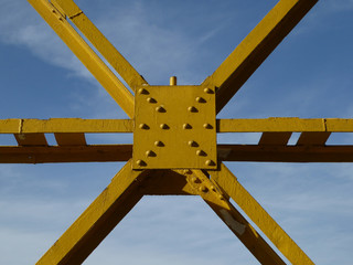 Yellow metal poles compound against blue sky