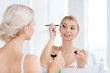 © Syda Productions - woman with makeup brush and eyeshade at bathroom