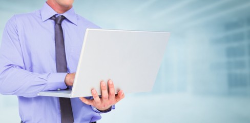 Poster - Composite image of businessman using a laptop