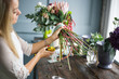 © cherry_d - Florist at work: pretty young blond woman making fashion modern bouquet of different flowers
