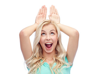 Wall Mural - happy smiling young woman making bunny ears