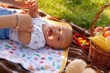 cute little baby boy with mother on picnic in the summer park