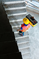 Builder or craftsman carrying a toolbox construction site