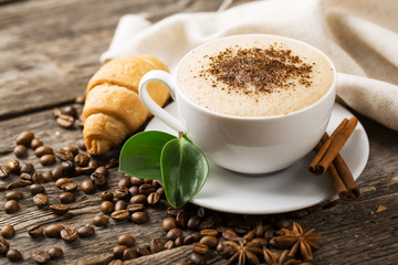 Wall Mural - Close-up of coffee cup with roasted coffee beans on wooden backg