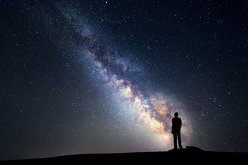 Wall Mural - milky way. night sky and silhouette of a standing man