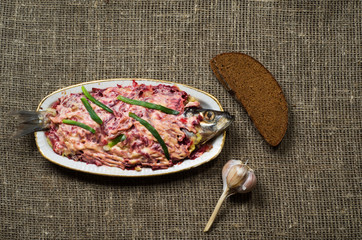  salad herring under a fur coat on a wooden table in the backgro