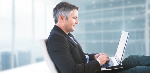 Poster - Composite image of businessman using laptop