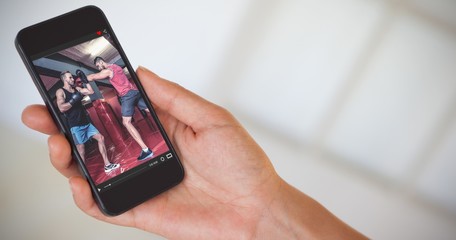 Wall Mural - Composite image of womans hand holding black smartphone