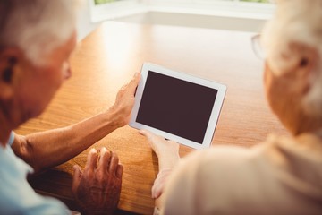 Wall Mural - Rear view of senior couple using tablet