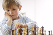 © Westend61 - Portrait of thinking little boy playing chess