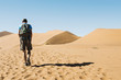 © Westend61 - Namibia, Namib Desert, man with backpack walking through the dunes