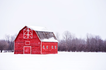 bright red barn with a hayloft in white winter landscape