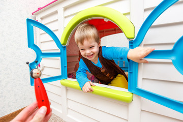 Funny little boy wants to get new toy from ones hand