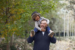 © Westend61 - Laughing little boy sitting on his father's shoulders