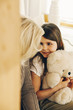 © Westend61 - Grandmother looking at granddaughter holding teddy bear