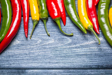 Colorful Background Of Red, Green And Yellow Peppers On Blue Wood.