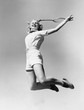 © everettovrk - Woman jumping into the air with a tennis racket in her hand