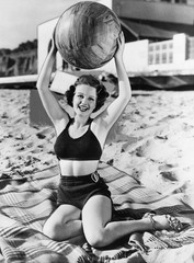 Portrait of woman with ball at beach 