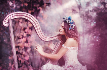 beautiful brown-haired woman with a flower wreath on her head, wearing a white dress playing the harp in the forest