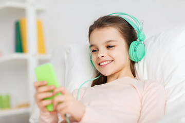 Poster - happy girl lying in bed with smartphone at home