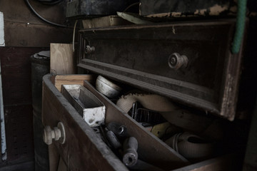 Open dusty old drawer full of tools in the workshop