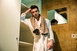 © theartofphoto - Young man wearing white bathrobe in spa