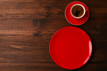 Empty red cup of coffee with a plate on the table. top view