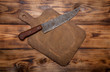 Retro cutting board and knife on old wooden burned table or boar