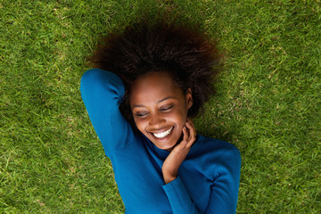 Smiling african woman lying on grass