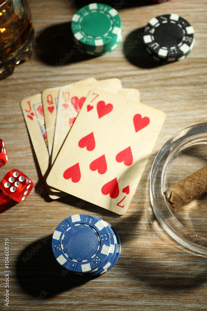 Set to playing poker with cards and chips on wooden table, top view