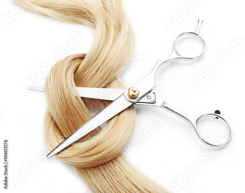 Naklejka na szybę Hairdresser's scissors with strand of blonde hair, isolated on white