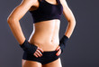 © lenets_tan - Muscular young woman  standing on gray background