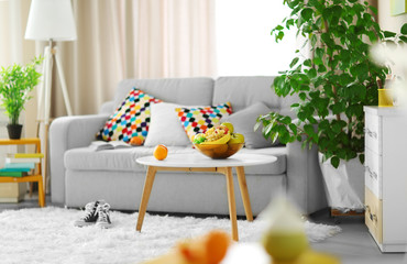 Canvas Print - Living room interior with sofa, table and green tree