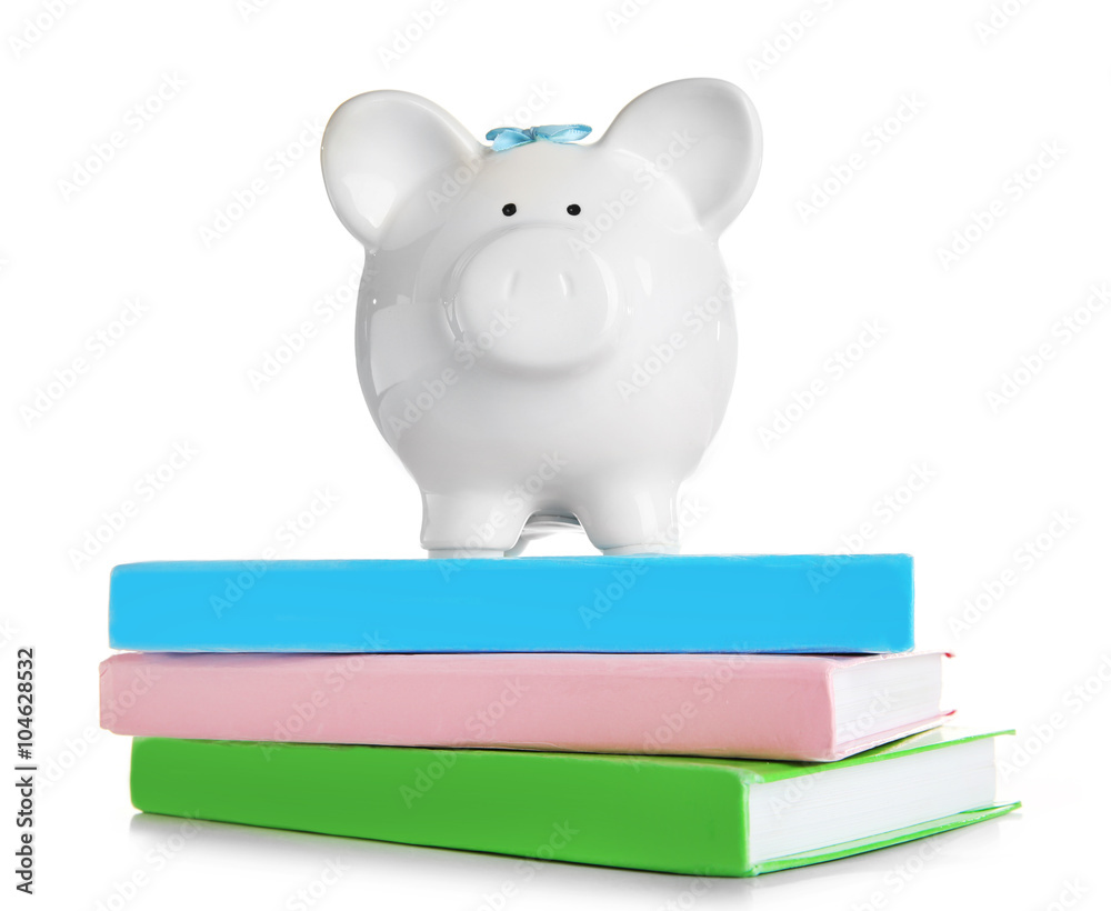 Piggy bank on books, isolated on white