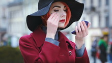 Young Beautiful Lady Correcting Her Makeup With Powder On The Street. Model Wearing Stylish Clothes. Closeup