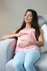 Wall Mural - Pregnant woman resting on sofa in the room