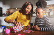 © Flamingo Images - Adult pouring beads on table for child