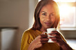 © Flamingo Images - Smiling friendly young black woman drinking coffee