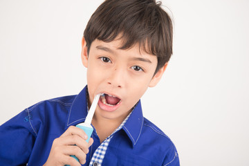 Wall Mural - Little boy using electric toothbrushes on white background