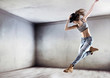 © konradbak - Athletic dancer jumping on a concrete wall background