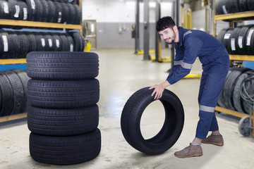 Mechanic carrying a tyre