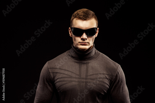 Combat muscled action hero man wearing shirt with pants and sunglasses.  Studio shot. Robocop Style - Buy this stock photo and explore similar  images at Adobe Stock | Adobe Stock