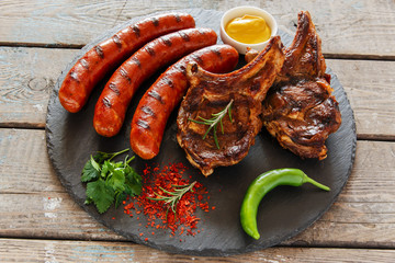 Grilled sausages and steak on the bone barbecue