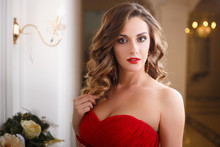 Beautiful Young Woman With Perfect Make Up And Hair Style In Gorgeous Red Evening Dress In Expensive Luxury Interior