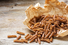 wholemeal pasta fusilli from organic whole grain spelt on a paper bag