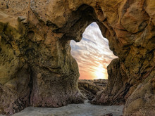 Ghost - The Sea Sculpted A Natural Arch In The Shape Of A Ghost. The Sunset Spills Through The Archway Off The Pacific Ocean Coastline In Laguna Beach, California.