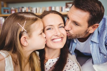 Poster - Close-up of father and daughter kissing mother